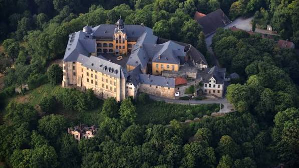 Luftaufnahme von Schloss Blankenburg im Harz, umgeben von Wald